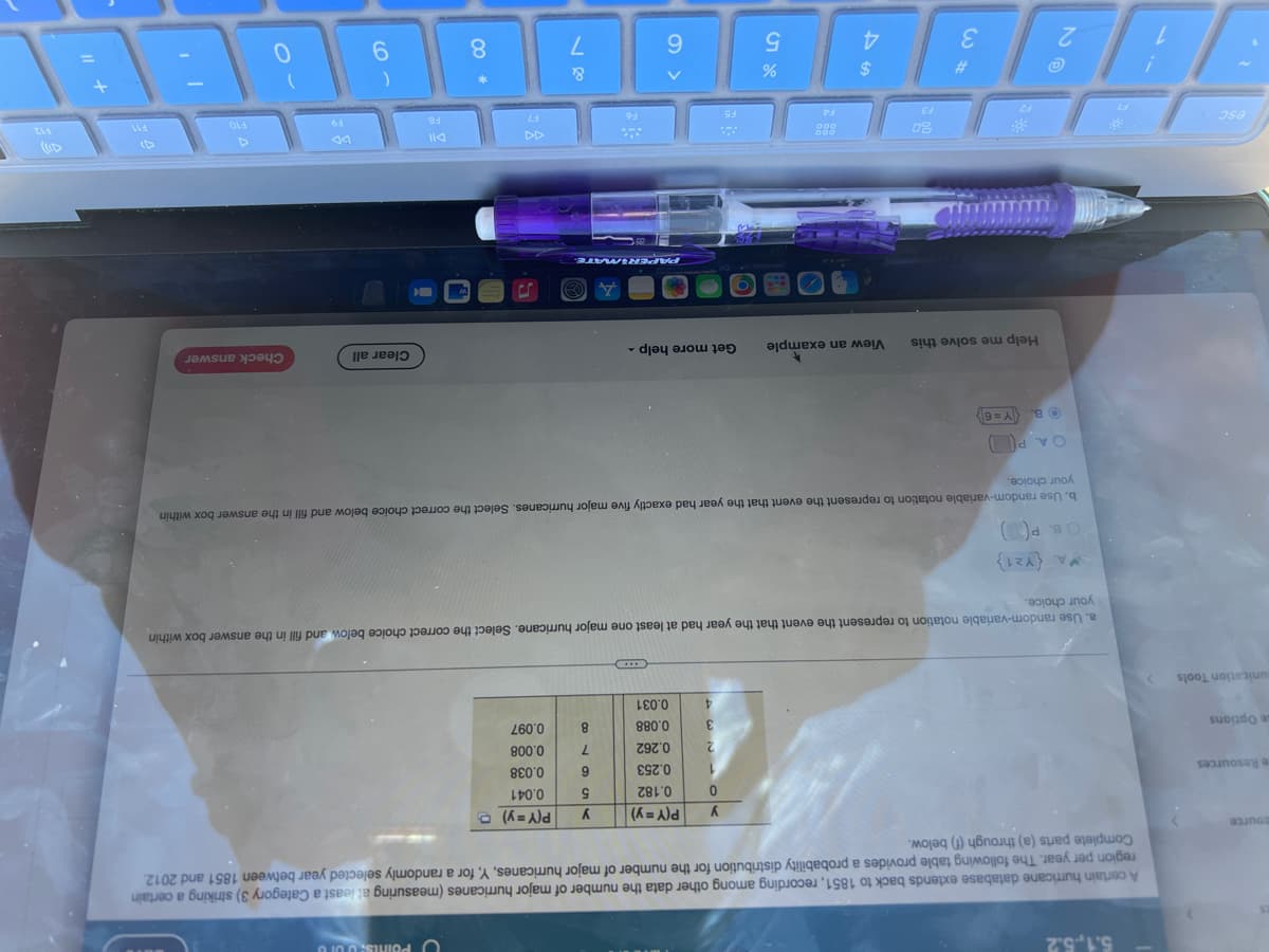 The image depicts a section of an educational webpage, likely focused on probability or statistics, displayed on a laptop with a visible purple pen lying on the keyboard. The screen is oriented upside-down in the image. Below is a detailed transcript and description of all visible elements, adapted as if for an educational website:

---

### Understanding Probability Distributions

**Practice Problem:**
Use the table of probabilities on this page to answer the questions that follow.

**Question:**
Select the correct choice below and fill in the answer box within your choice:

**Random Variable Definition:** The random variable \(Y\) represents the number of major hurricanes in a certain region within a year.

| \(Y\) | \(P(Y = y)\) |
|------|-------------|
| 0    | 0.1         |
| 1    | 0.2         |
| 2    | 0.3         |
| 3    | 0.25        |
| 4    | 0.1         |
| 5    | 0.05        |

1. **Calculate the Mean (Expected Value)**:
   \( E[Y] = \sum (Y \cdot P(Y = y)) \)

2. **Calculate the Variance**:
   \[
   Var(Y) = E[Y^2] - (E[Y])^2
   \]
   
3. **Calculate the Standard Deviation**:
   \( SD(Y) = \sqrt{Var(Y)} \)

**Options:**
- (A) The calculation for the mean:
\[ E[Y] = \sum Y \cdot P(Y) = ? \]
  * Enter your choice and calculation.

- (B) The calculation for the variance:
\[ Var(Y) = ? \]
  * Enter your choice and calculation.

- (C) The calculation for the standard deviation:
\[ SD(Y) = ? \]
  * Enter your choice and calculation.

**Tips and Tricks:**
For additional help, you can:
- View an example by selecting "Get more help."
- Review the exact sample problems to solidify your understanding.

**Button Options:**
- [Check Answer]
- [Clear All]

---

**Graphical Representation:**
The data provided can be visualized using a bar graph where the \(x\)-axis represents the number of major hurricanes (Y) and the \(y\)-axis shows the probability of each event (\(