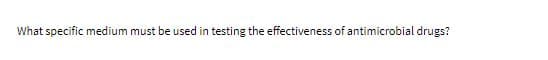 What specific medium must be used in testing the effectiveness of antimicrobial drugs?
