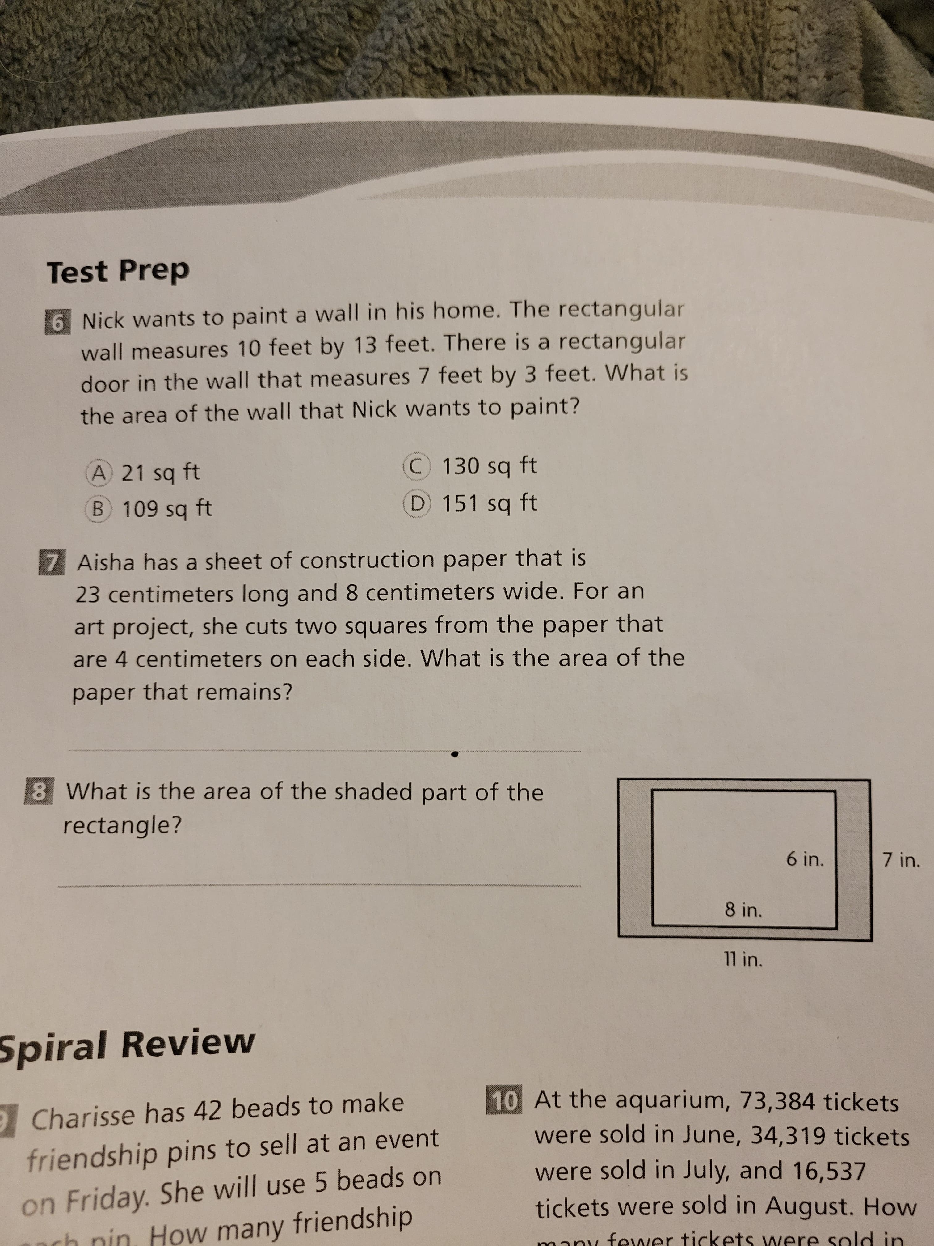 Test Prep
6 Nick wants to paint a wall in his home. The rectangular
wall measures 10 feet by 13 feet. There is a rectangular
door in the wall that measures 7 feet by 3 feet. What is
the area of the wall that Nick wants to paint?
A 21 sq ft
C130 sq ft
B 109 sq ft
(D 151 sq ft
7 Aisha has a sheet of construction paper that is
23 centimeters long and 8 centimeters wide. For an
art project, she cuts two squares from the paper that
are 4 centimeters on each side. What is the area of the
paper that remains?
8 What is the area of the shaded part of the
rectangle?
6 in.
7 in.
wwww
8 in.
11 in.
Spiral Review
10 At the aquarium, 73,384 tickets
were sold in June, 34,319 tickets
9Charisse has 42 beads to make
friendship pins to sell at an event
on Friday. She will use 5 beads on
ach nin How many friendship
were sold in July, and 16,537
tickets were sold in August. How
many fewer tickets were sold in
