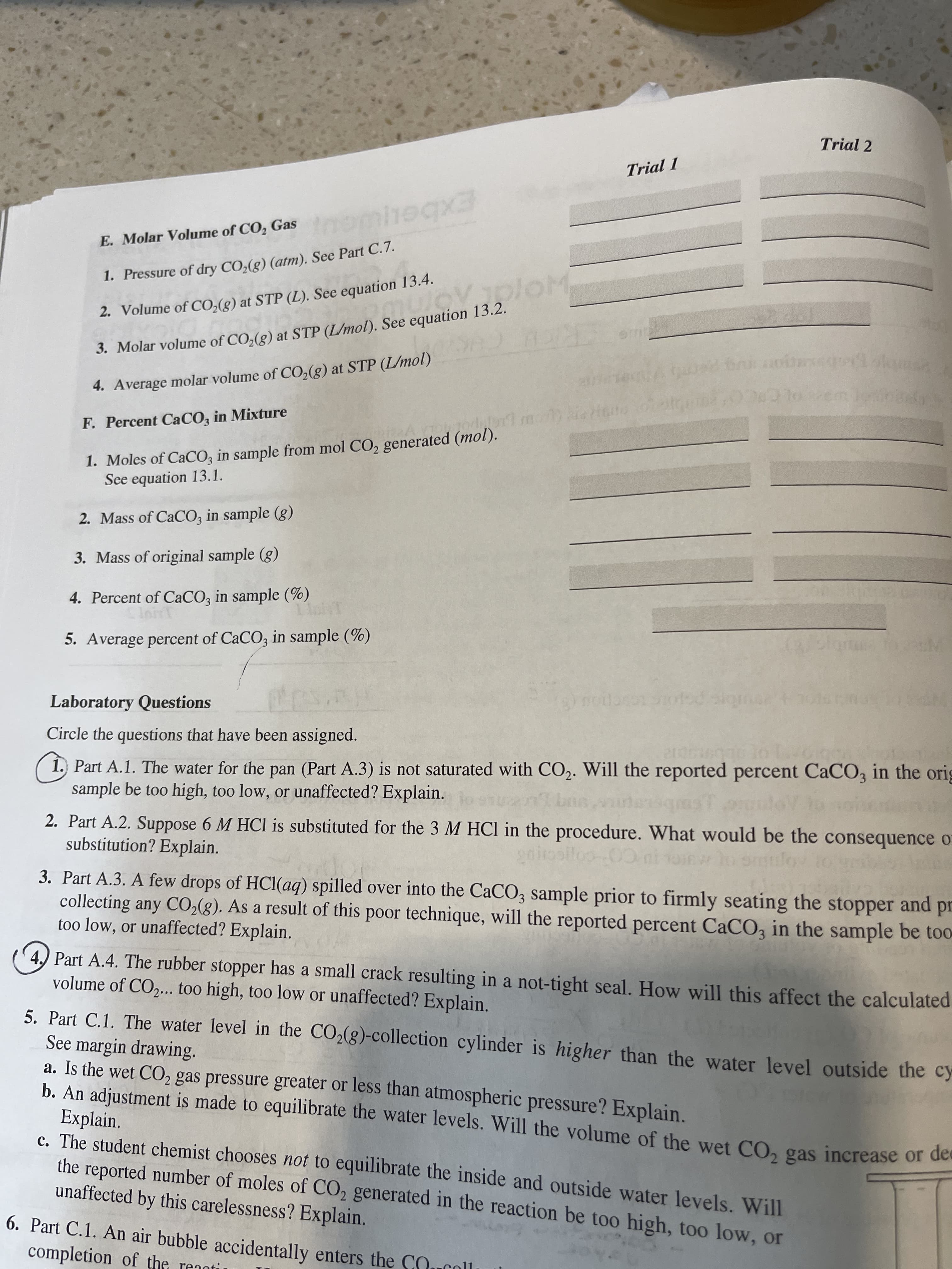 Trial 2
Trial 1
Imomhegx3
E. Molar Volume of CO, Gas
1. Pressure of dry CO,(g) (atm). See Part C.7.
2. Volume of CO,(g) at STP (L). See equation 13.4.
3. Molar volume of CO,(g) at STP (L/mol). See equation 13.2.
4. Average molar volume of CO,(g) at STP (L/mol)
F. Percent CaCO, in Mixture
1. Moles of CaCO; in sample from mol CO, generated (mol).
See equation 13.1.
2. Mass of CaCO; in sample (g)
3. Mass of original sample (g)
4. Percent of CaCO, in sample (%)
IninT
5. Average percent of CaCO, in sample (%)
Laboratory Questions
Circle the questions that have been assigned.
1. Part A.1. The water for the pan (Part A.3) is not saturated with CO2. Will the reported percent CaCO, in the orig
sample be too high, too low, or unaffected? Explain.
2. Part A.2. Suppose 6 M HCl is substituted for the 3 M HCI in the procedure. What would be the consequence o
substitution? Explain.
3. Part A.3. A few drops of HCl(aq) spilled over into the CaCO3 sample prior to firmly seating the stopper and pr
collecting any CO2(g). As a result of this poor technique, will the reported percent CaCO, in the sample be too
too low, or unaffected? Explain.
4.) Part A.4. The rubber stopper has a small crack resulting in a not-tight seal. How will this affect the calculated
volume of CO,... too high, too low or unaffected? Explain.
5. Part C.1. The water level in the CO2(g)-collection cylinder is higher than the water level outside the cy
See margin drawing.
a. Is the wet CO2 gas pressure greater or less than atmospheric pressure? Explain.
b. An adjustment is made to equilibrate the water levels. Will the volume of the wet CO, gas increase or de
Explain.
c. The student chemist chooses not to equilibrate the inside and outside water levels. Will
the reported number of moles of CO2 generated in the reaction be too high, too low, or
unaffected by this carelessness? Explain.
6. Part C.1. An air bubble accidentally enters the COucoll
completion of the reaotir
