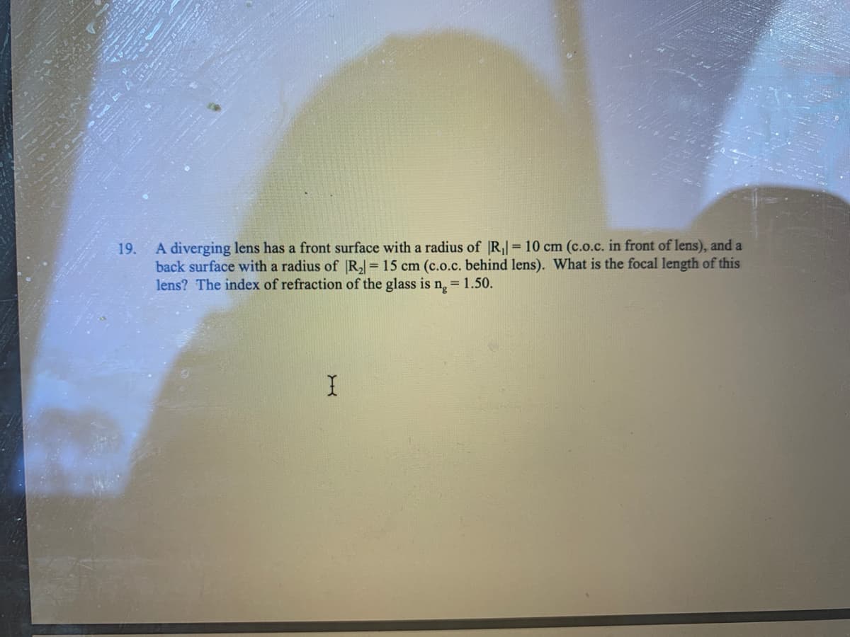 A diverging lens has a front surface with a radius of |R,| = 10 cm (c.o.c. in front of lens), and a
back surface with a radius of R = 15 cm (c.o.c. behind lens). What is the focal length of this
lens? The index of refraction of the glass is n,= 1.50.
19.
