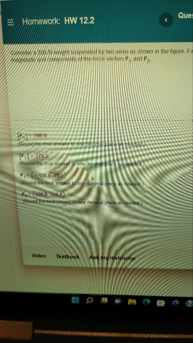 Ques
Homework: HW 12.2
Consider a 200-N weight suspended by two wires as shown in the figure. Fir
magnitude and components of the force vectors F. and F
F₁-146.4
(Round the final answer to one decimal place as needed)
F2 = 179.3
(Round the final answer to one decimal place as needed.)
F₁--126.8 73.2)
(Round the final answer to one decimal place as needed.
F 126.8. 126.8)
(Round the final answer to one decimal place as needed.)
Video
Textbook Ask my instructor