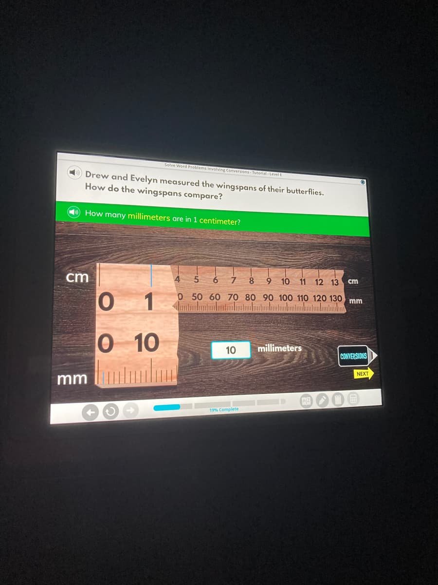 Solve Word Problems Involving Conversions- Tutorial - Level B
Drew and Evelyn measured the wingspans of their butterflies.
How do the wingspans compare?
How many millimeters are in 1 centimeter?
cm
10
11 12 13
cm
0 1
0 50 60 70 80 90 100 110 120 130 mm
0 10
10
millimeters
CONVERSIONS
NEXT
mm
AZ
19% Complete
