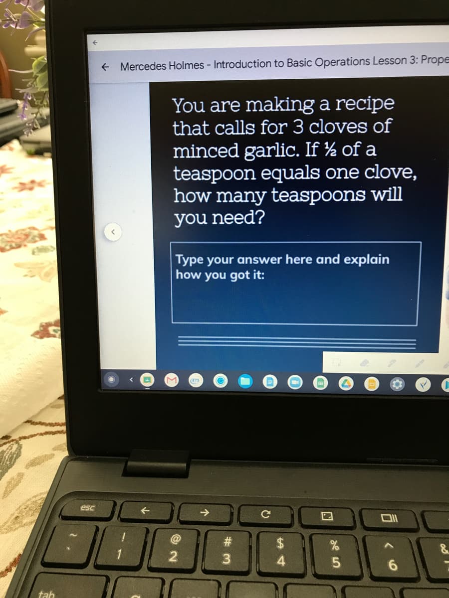 **Mercedes Holmes - Introduction to Basic Operations Lesson 3: Proportions**

### Problem Statement

**You are making a recipe that calls for 3 cloves of minced garlic. If ½ of a teaspoon equals one clove, how many teaspoons will you need?**

---

**Type your answer here and explain how you got it:**

---

### Explanation

The image shows a laptop screen displaying an educational exercise within a math course titled "Introduction to Basic Operations Lesson 3: Proportions". The problem requires the student to calculate the number of teaspoons needed if ½ of a teaspoon represents one clove of garlic and the recipe requires 3 cloves. The interface includes a section where the students can type their answers and explain their reasoning process.

To solve this problem, you need to use basic multiplication:

1. One clove of garlic = ½ teaspoon.
2. Three cloves of garlic = 3 * ½ = 1½ teaspoons.

So, you will need 1½ teaspoons of minced garlic for the recipe.