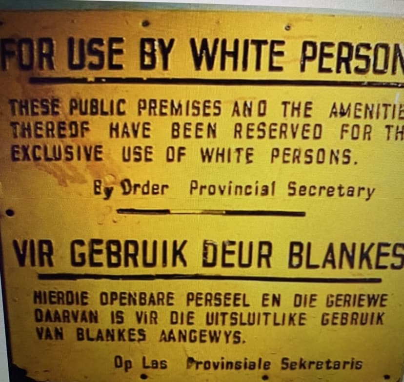 FOR USE BY WHITE PERSON
THESE PUBLIC PREMISES ANO THE AMENITIE
THEREOF HAVE BEEN RESERVED FOR THE
EXCLUSIVE USE OF WHITE PERSONS.
EDrder Provincial Secretary
VIR GEBRUIK DEUR BLANKES
HIERDIE OPENBARE PERSEEL EN DIE GERIEWE
DAARVAN IS VIR DIE UITSLUITLIKE GEBRUIK
VAN BLANKES AANGEWYS.
Op Las Provinsiale Sekretaris
