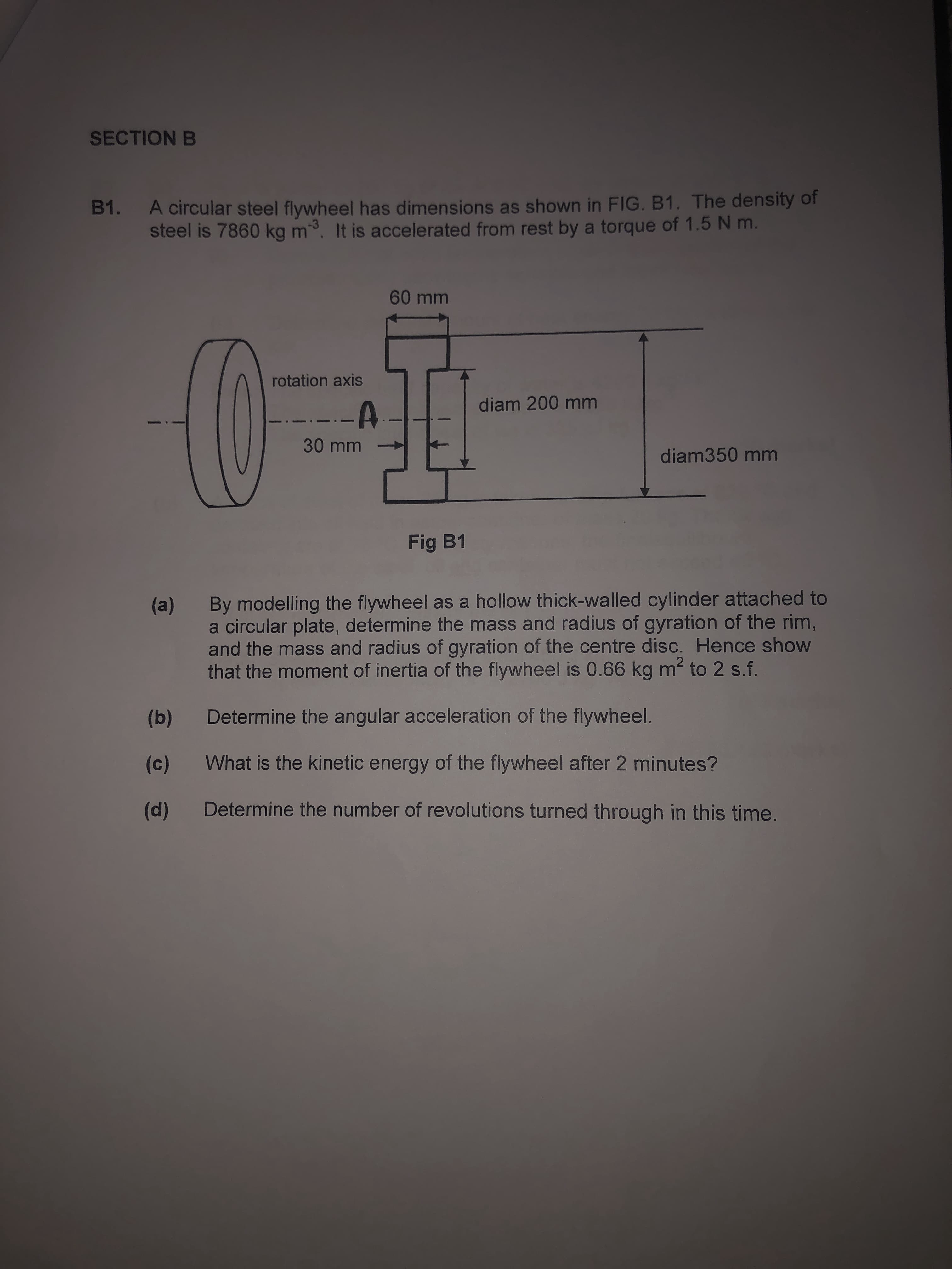 A circular steel flywheel has dimensions as shown in FIG. B1. The density of
steel is 7860 kg m. It is accelerated from rest by a torque of 1.5 N m.
-3
