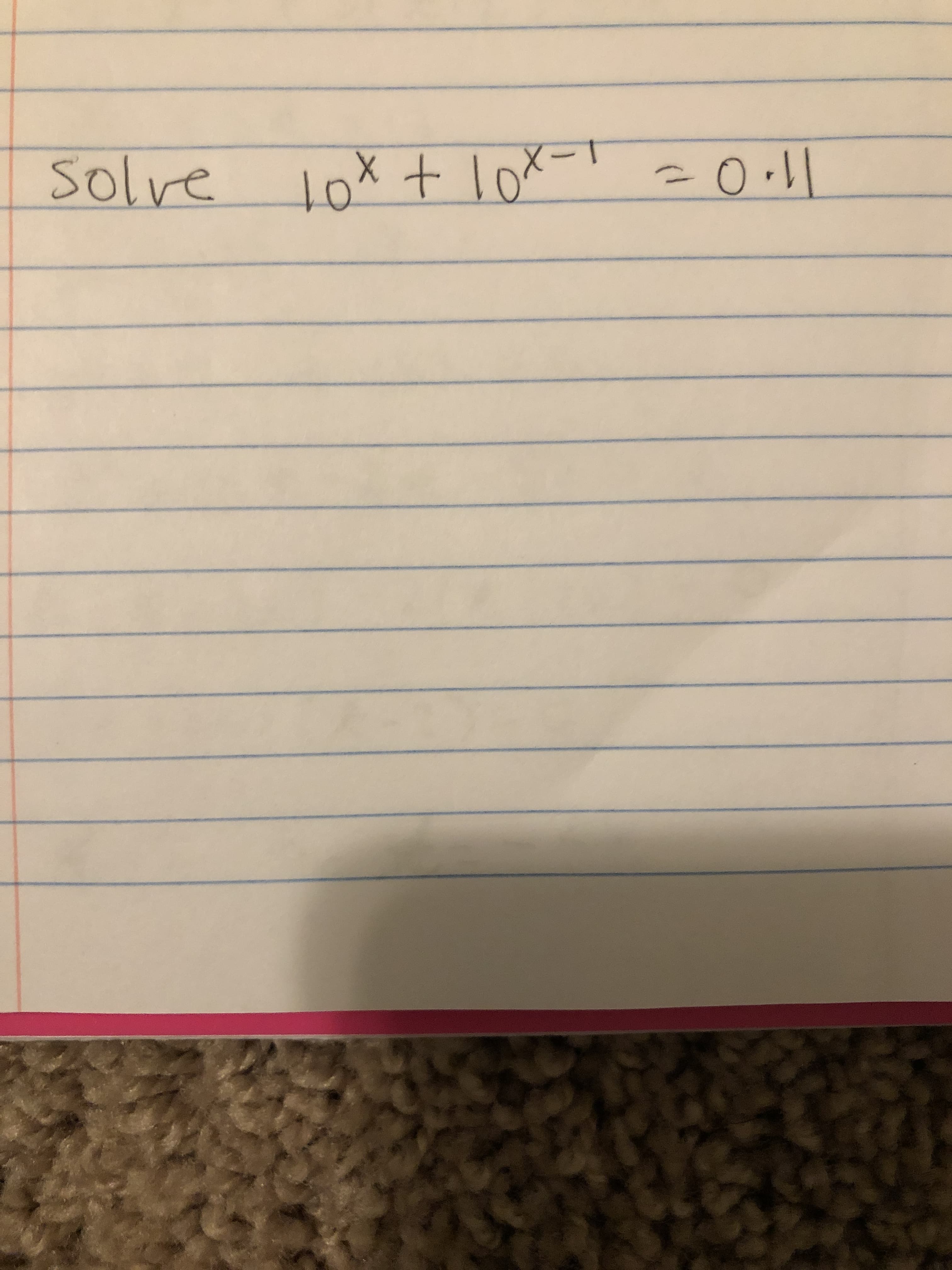 The image contains the following mathematical equation handwritten on lined paper:

"solve \(10^x + 10^{x-1} = 0.1\)"