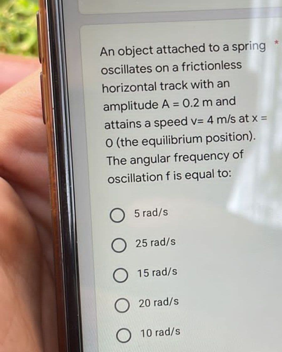 An object attached to a spring
oscillates on a frictionless
horizontal track with an
amplitude A = 0.2 m and
attains a speed v= 4 m/s at x =
O (the equilibrium position).
The angular frequency of
oscillation f is equal to:
5 rad/s
25 rad/s
15 rad/s
O 20 rad/s
10 rad/s